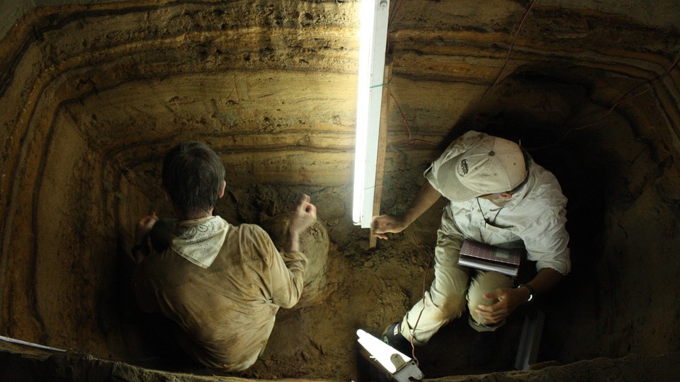 Kerry Sieh and Charles Rubin use fluorescent lights to look for charcoal and shells for radiocarbon dating.