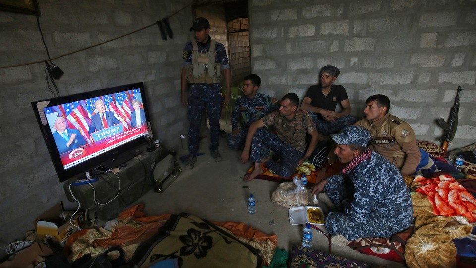 Members of the Iraqi forces watch Donald Trump giving a speech after he won the U.S. president election.