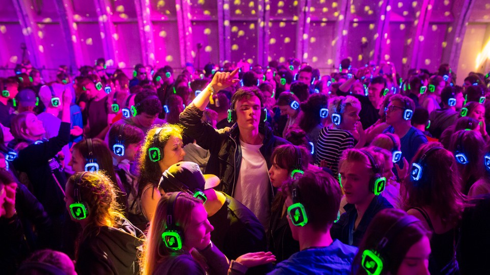 People dance while wearing glowing headphones