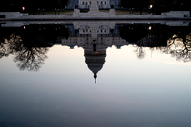 A photograph of the U.S. Capitol Building reflected upside down in the reflecting pool on the National Mall