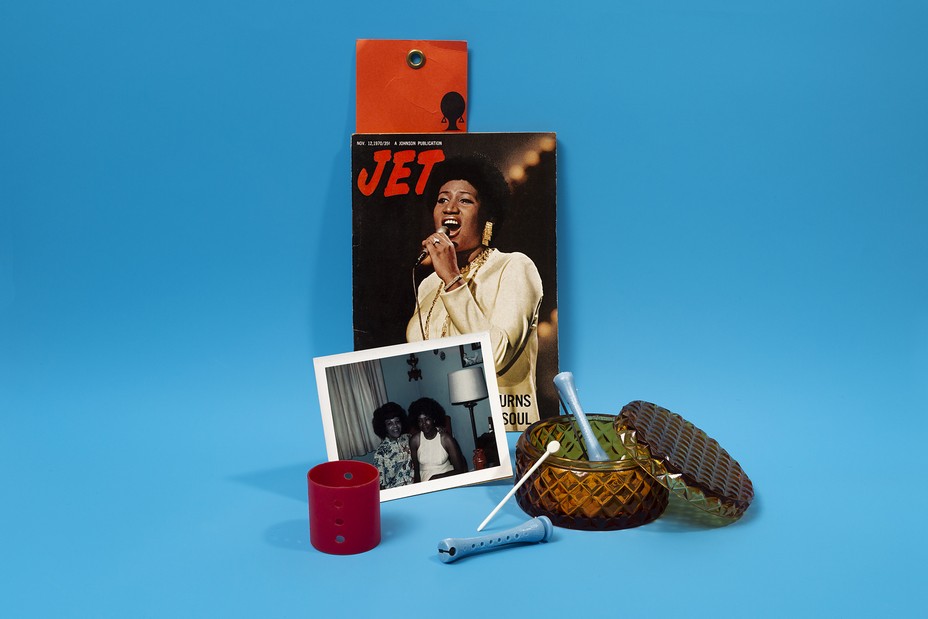 Still life of Jet magazine, hair products, and photograph on blue