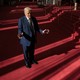 Donald Trump stands with his arms outreached on the red carpeted walkway in the Kennedy Center