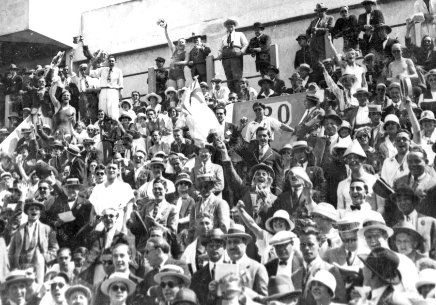 Many cheering spectators in the stands of a stadium