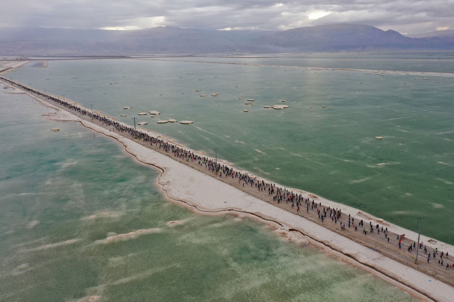 An aerial picture of competitors running on a strip of land across the Dead Sea.