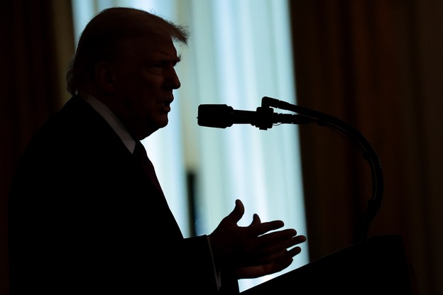 Trump speaking to a microphone