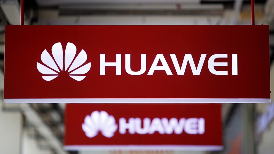 Huawei signs hang from a ceiling.