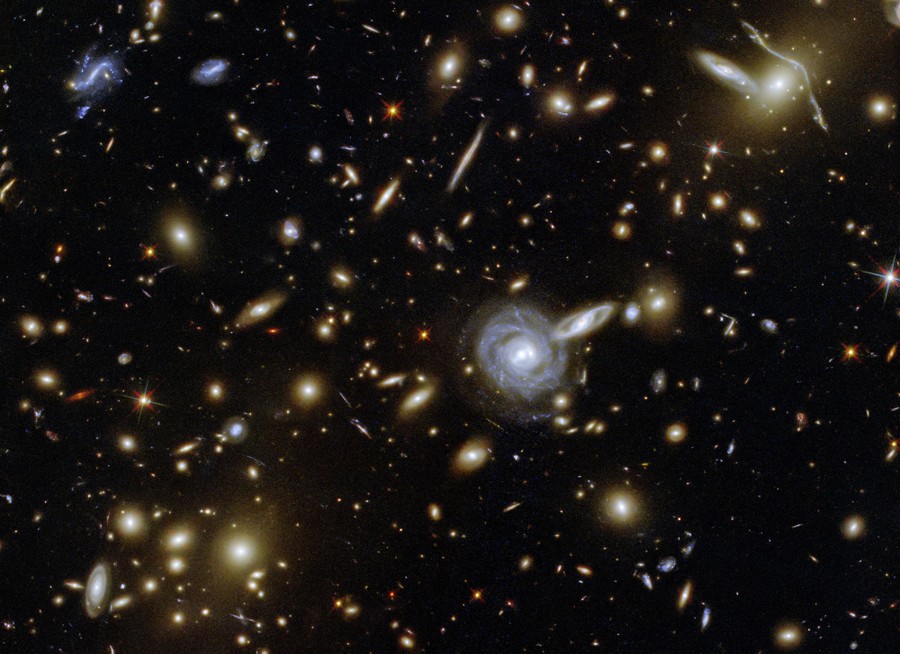 Dozens of galaxies of varying sizes, shapes, and orientations, appearing clustered together