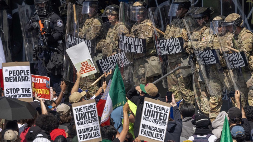Protesters in LA line up against a wall of National Guard members with shields