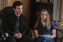 Nathan Fielder and Emma Stone sitting next to each other looking glum