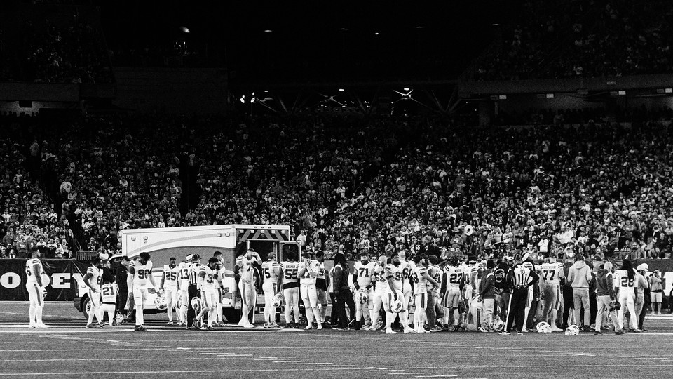 Buffalo Bills players congregate on the field by an ambulance