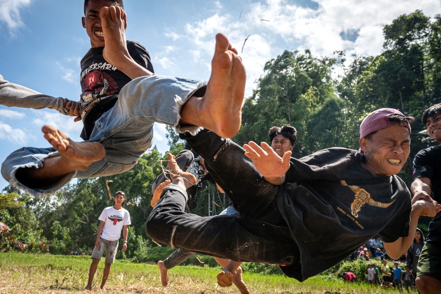 Two men leap and kick at each other during a ritualistic fight.
