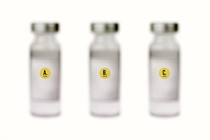 three blurred vaccine vials labeled A, B, and C