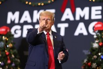 Trump on a Christmas-decorated "Make America Great Again" podium, pointing at the camera