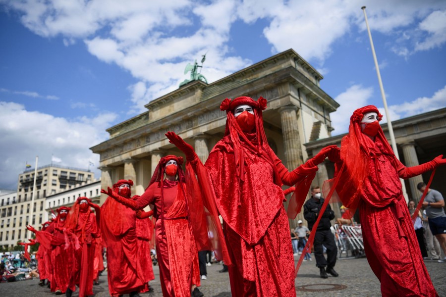 Protesters dressed in red costumes march.