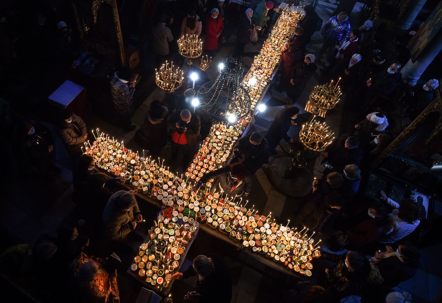 An overhead view of hundreds of lit candles inside a church.