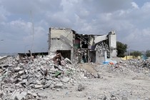 Photo of a destroyed building surrounded by rubble