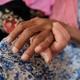 young hand underneath elderly hand