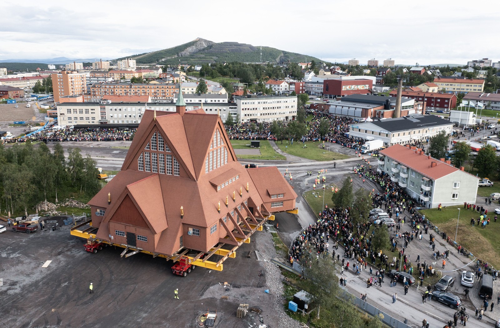 An aerial view of a church that is being moved as it navigates a tight corner.