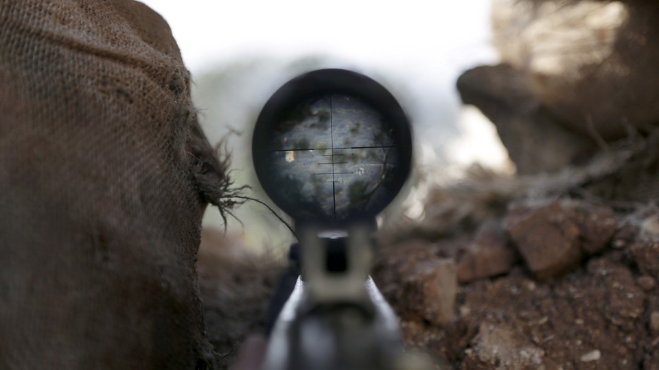 A view is seen through the scope of a weapon in the northwestern Syrian city of Idlib.