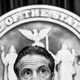 The top half of New York governor Andrew Cuomo's head is shown in front of the seal of the state of New York.