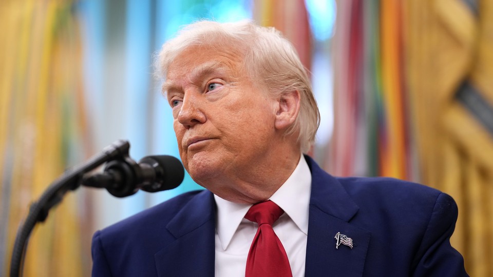 Donald Trump looks off to the side with a microphone in front of him