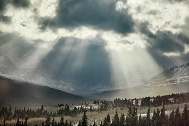 Photo of Glacier National Park, Montana, with light streaming through the clouds