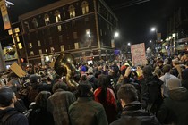 A crowd of protesters, including some with signs and one with a tuba, fill the streets in Berkeley, California, protesting a speech by Milo Yiannopoulos