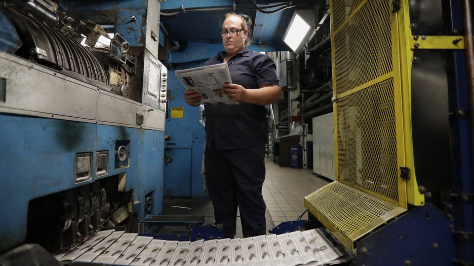 An employee surveying print newspapers