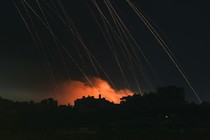 Long exposure picture taken from southern Israel near the border with the Gaza Strip shows Israeli shells falling on north Gaza on December 1, 2023.