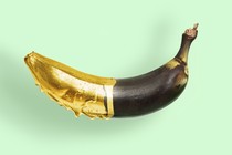 An illustration showing a rotten banana painted in gold