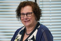 Photo of a woman in glasses and a black-pearl necklace