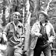 Robert F. Kennedy and Supreme Court Justice William O. Douglas hiking through the woods wearing outdoors gear.