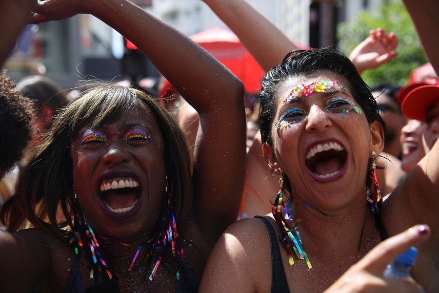 Smiling people enjoy a pre-Carnival block party.