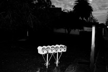 A row of white mailboxes glow in the flash of a photo taken at nighttime