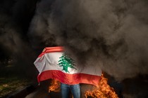 A protester holds up the Lebanese flag on the streets of Beirut.