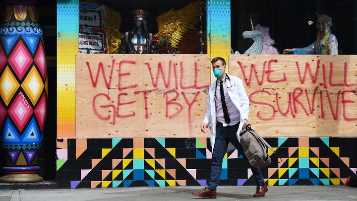 A doctor with the Haight Ashbury Free Clinic walks by a supportive sign in San Francisco.