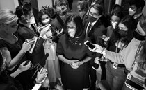 A black-and-white photo of Representative Pramila Jayapal of Washington State surrounded by reporters
