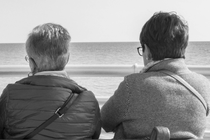 Two people on a bench looking at the water