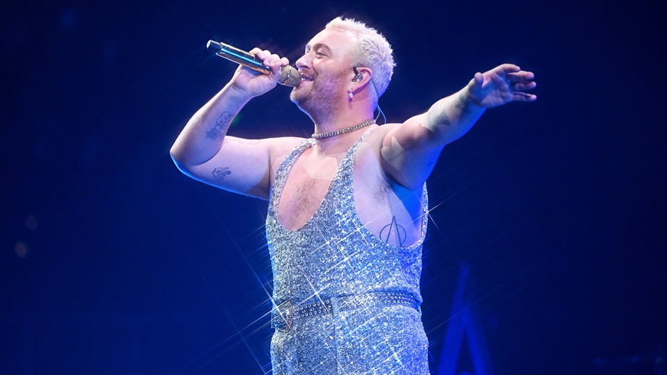 Sam Smith performing onstage in a glittering light-blue jumpsuit