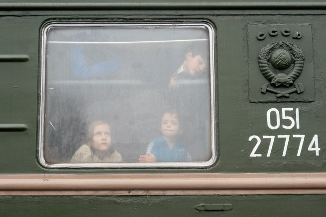 Chechen children look out a train window.