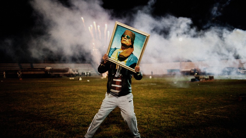 A Gaddafi supporter holds a portrait of the Libyan leader during a 2011 celebration.
