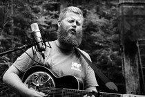 Singer-songwriter Oliver Anthony playing guitar and singing