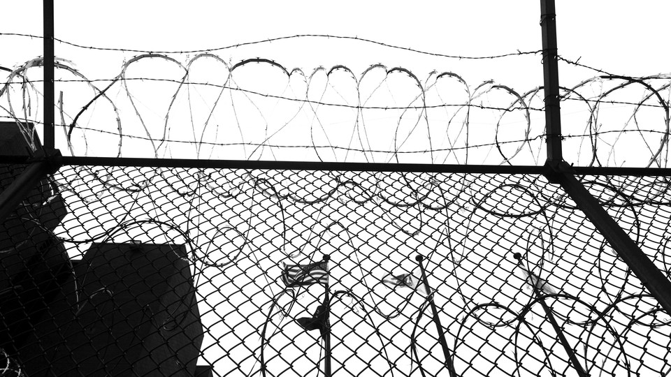 black and white photo of a barbed wire prison fence