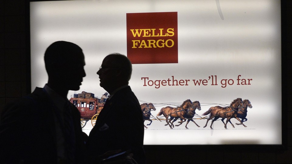 Patrons stand outside a Wells Fargo bank