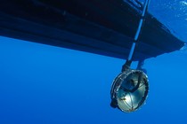 An underwater microphone hangs from a boat