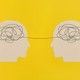 Human heads with gears on yellow background