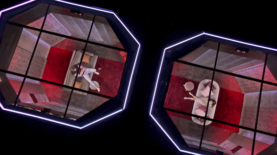 An image from "Love is Blind": A man and woman sit in opposite pods