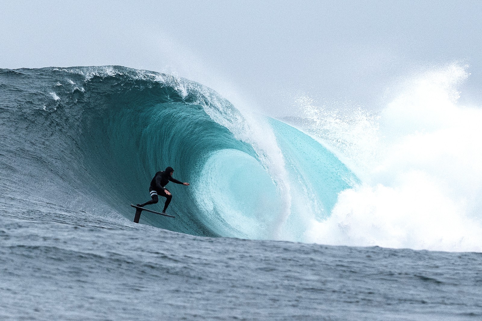 A surfer on a foil board rides a wave.