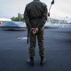 An Iranian police officer stands at a busy traffic intersection.