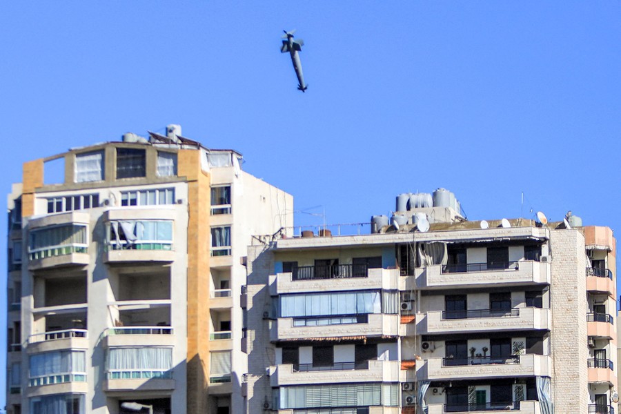 A bomb dropped by an Israeli war plane falls toward a building.